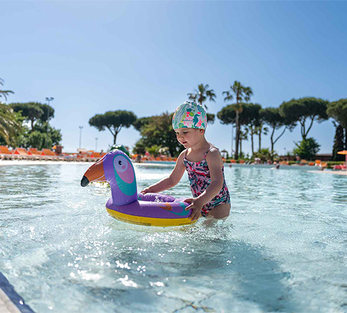 Bambina che gioca con il gonfiabile in piscina