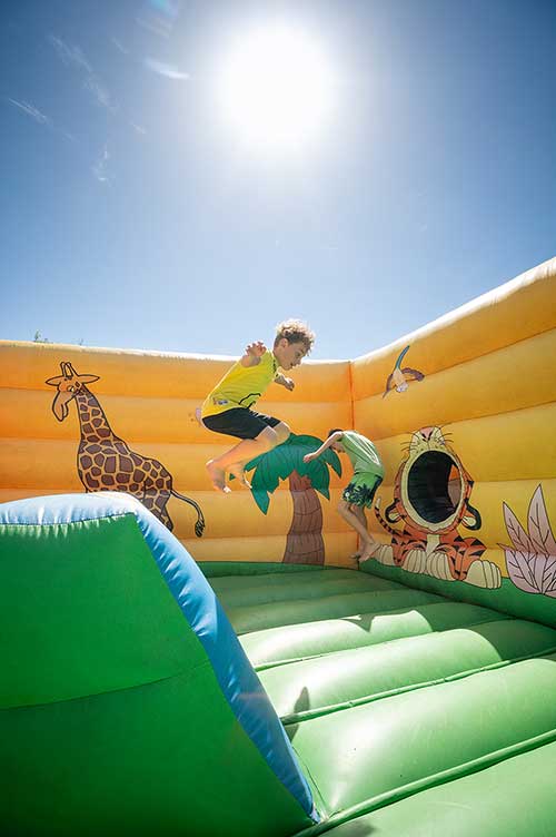 Kinder spielen auf den Hüpfburgen auf dem Spielplatz des Pappasole Camping Village.