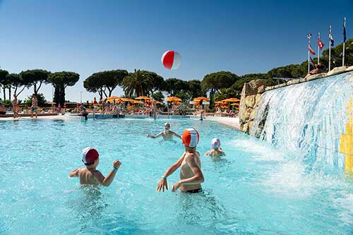 Kinder spielen mit einem Ball im Pool