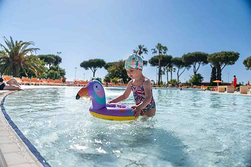 Kleines Mädchen mit Schwimmweste im Pool