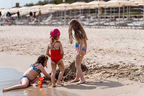 Kleine Mädchen spielen am Ufer