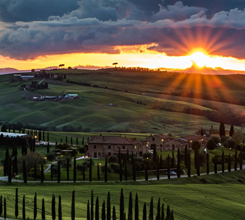 Paesaggio toscano con colline e cipressi al tramonto, tipico della campagna della Toscana